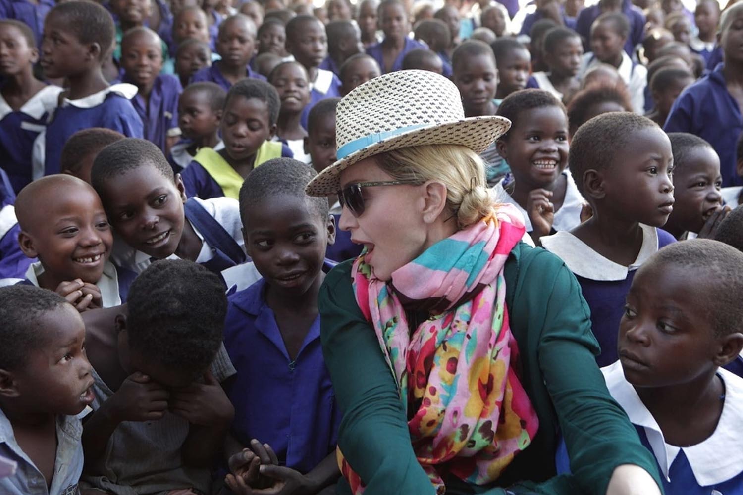 Madonna entre crianças que frequentam escola ajudada por ela, no Malawi.